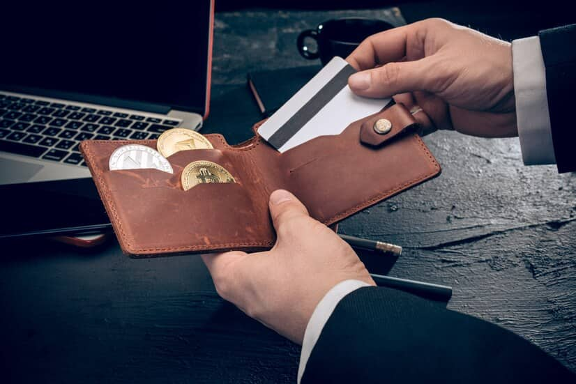 Man Holds Wallet with Crypto and Credit Cards